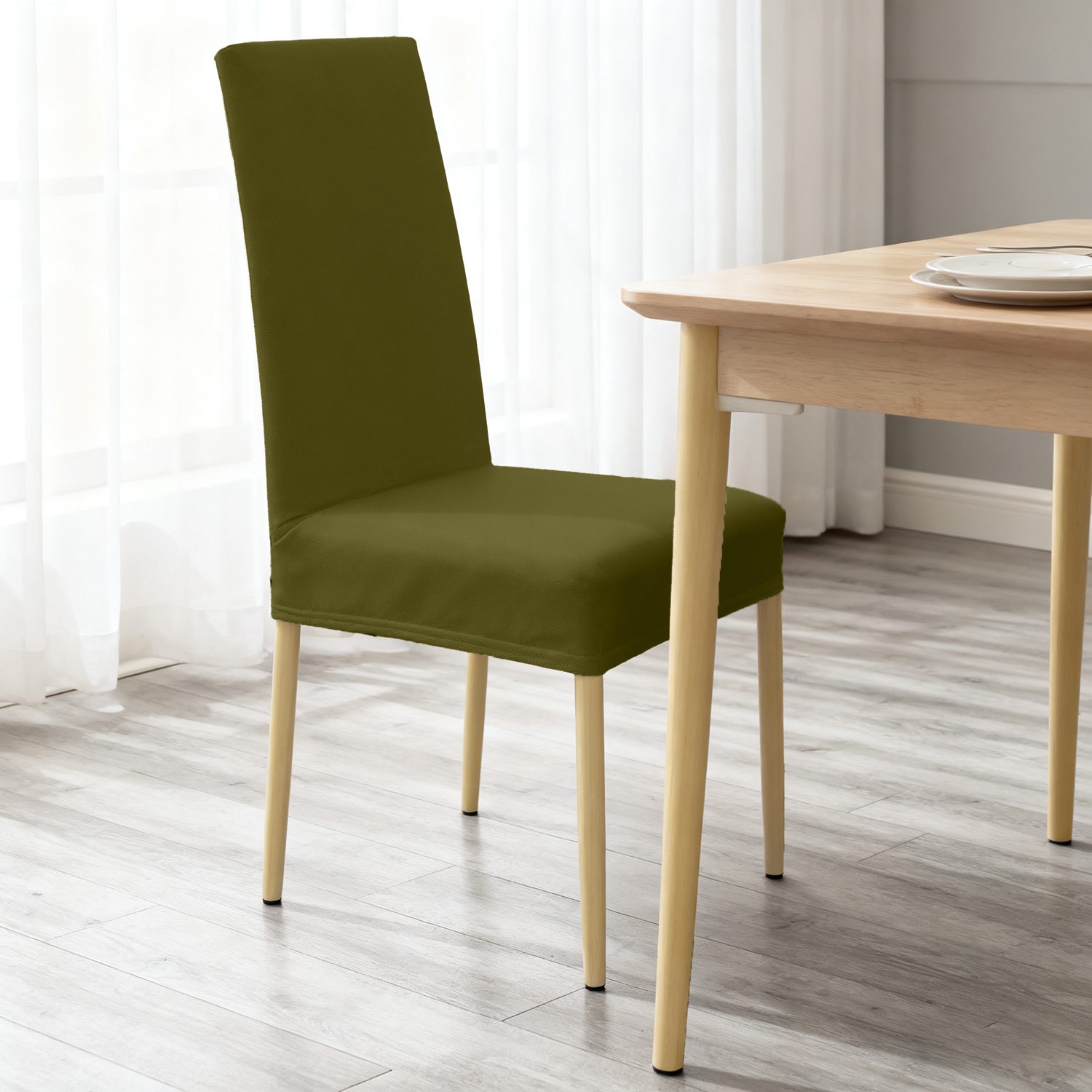 Silla con funda verde oliva junto a una mesa de madera