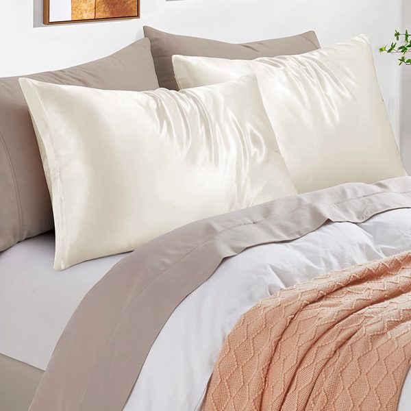 Cama con fundas de almohada de satén beige