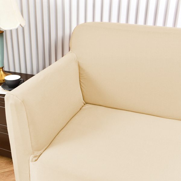 Sofá con funda beige junto a una mesa de noche